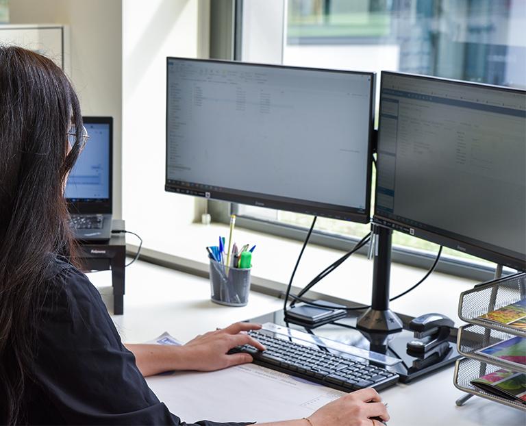 employée en poste à son bureau devant son écran d'ordinateur