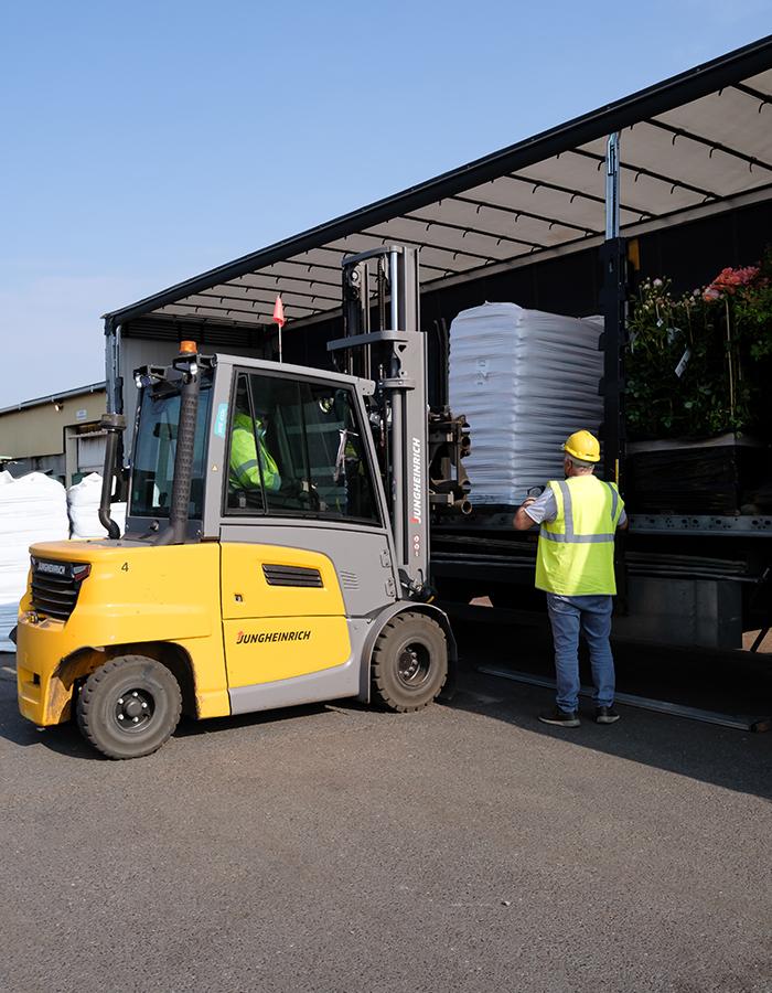 Chargement d'une palette de sacs de terreau dans un camion